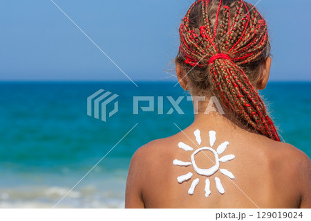 Sunscreen Sun Drawing on Girls Back at the Beach Sunscreen Sun Drawing on Girls Back at the Beach 129019024