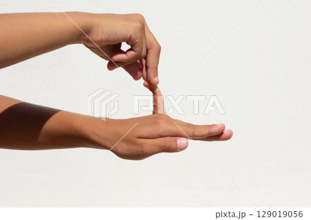 Child showing flexible little finger on white background 129019056