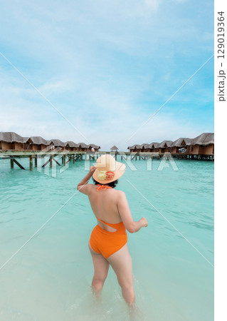 woman swimming and hat enjoy a sunny day at a seaside villa woman swimming and hat enjoy a sunny day at a seaside villa 129019364