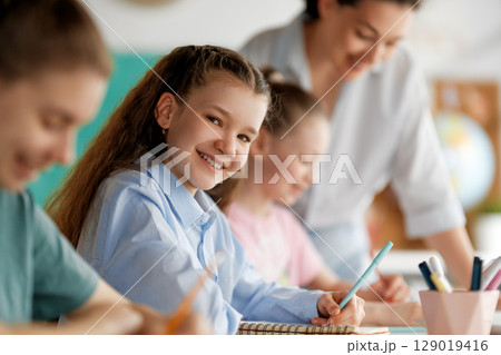 Happy kids and teacher at school Happy kids and teacher at school 129019416