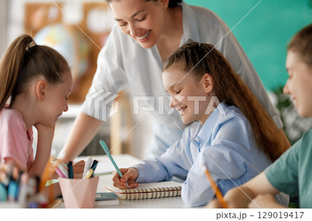 Happy kids and teacher at school 129019417