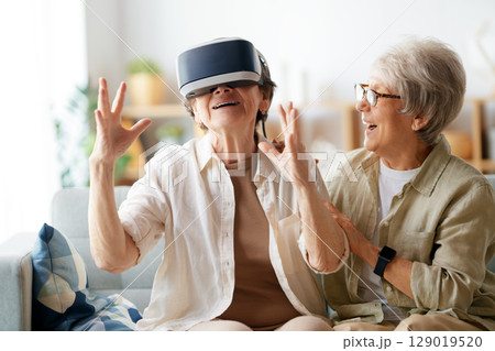 women playing console games wearing vr goggles women playing console games wearing vr goggles 129019520