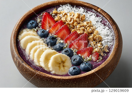 Healthy dish. Colorful acai bowl with banana slices, coconut flakes and granola on a white background.  Healthy and Wellness Breakfast for luxury resorts. 129019609