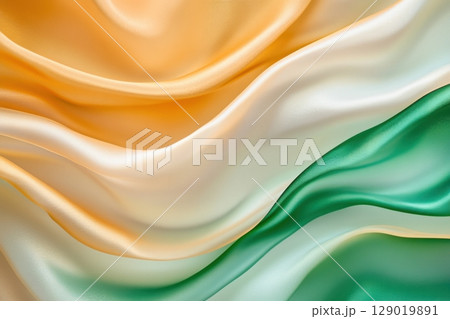Translucent fabric layers in golden and emerald green colors gently flowing under soft natural light 129019891