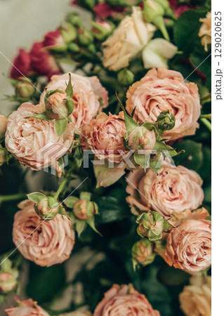 beautiful bouquet pink and cream roses in floral arrangement at important event. vertical. closeup. beautiful bouquet pink and cream roses in floral arrangement at important event. vertical. closeup. 129020625