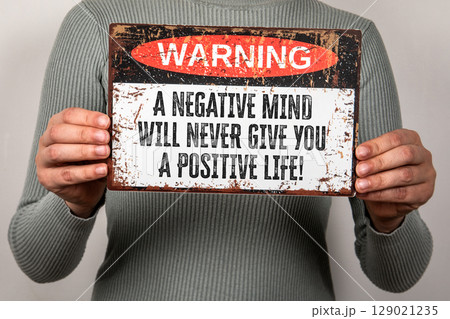 Warning Sign with Motivational Quote About Mindset and Positive Thinking Held by Person Warning Sign with Motivational Quote About Mindset and Positive Thinking Held by Person 129021235