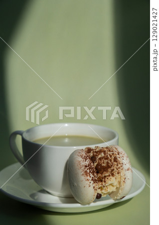 Sweet macaron dessert Cup of green plant based matcha tea latte in cozy morning atmosphere. Creative holiday romantic date idea. Herbal prebiotic fiber superfood beverage antioxidant-rich immunity Sweet macaron dessert Cup of green plant based matcha tea latte in cozy morning atmosphere. Creative holiday romantic date idea. Herbal prebiotic fiber superfood beverage antioxidant-rich immunity 129021427