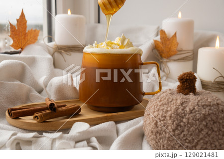 Autumn hygge Orange Cup of warm coffee autumn leaves on table against raindrops are running down the glass in window. Cozy fall still life footage burning candles. Thanksgiving and Halloween holiday 129021481
