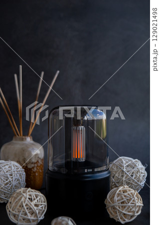 Indoors Decoration with modern lighted Air Humidification Aroma essential oil perfume fragrance. Scented home wellness wellbeing habit. Concept of feeling good spiritual health Indoors Decoration with modern lighted Air Humidification Aroma essential oil perfume fragrance. Scented home wellness wellbeing habit. Concept of feeling good spiritual health 129021498