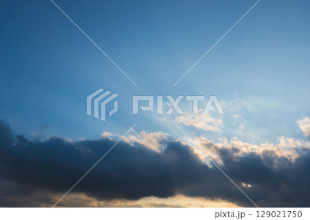 夕日が雲に隠れながら空を照らす27 129021750