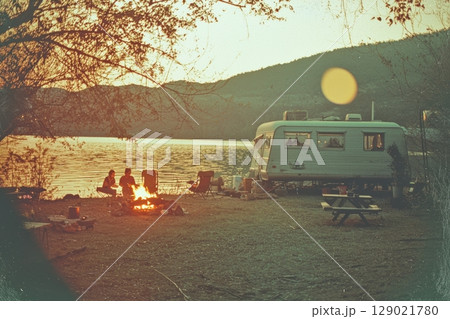 Vintage Lakeside Campsite With Cozy Campfire And Retro Caravan In Nostalgic Postcard Style. Evokes Warmth And Serene Outdoor Memories Vintage Lakeside Campsite With Cozy Campfire And Retro Caravan In Nostalgic Postcard Style. Evokes Warmth And Serene Outdoor Memories 129021780