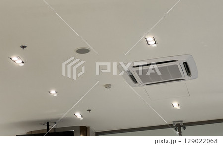 White ceiling with modern air conditioner system for ventilation and cooling. Interior space with recessed lighting technology. clean and comfortable atmosphere for an office 129022068