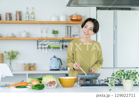 キッチンで調理するミドルの主婦 129022711