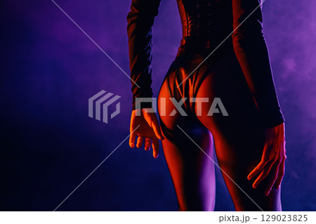 Sexy woman in leather bodysuit corset stands her buttocks to camera, dance moves 129023825