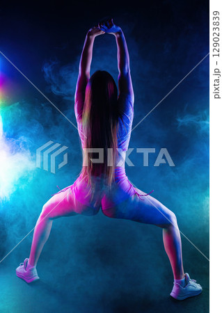 Hot Woman Dancing, Shaking, Twerking Buttocks In Multicolor Light, Dark Studio 129023839