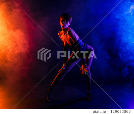Dominatrix Woman In Sexy Corset Dancing In Colorful Pink Light. Mistress, Fetish Dominatrix Woman In Sexy Corset Dancing In Colorful Pink Light. Mistress, Fetish 129023860