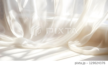 sheer white curtains draped in sunlight 129024376