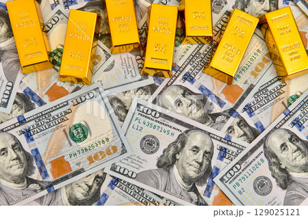 Paper us 100 dollar bill with gold bars, concept of investment and saving, wealth Paper us 100 dollar bill with gold bars, concept of investment and saving, wealth 129025121