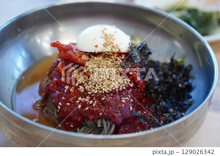 Close-up of Korean Buckwheat Noodles with Braised Pollack in Metal Bowl Close-up of Korean Buckwheat Noodles with Braised Pollack in Metal Bowl 129026342