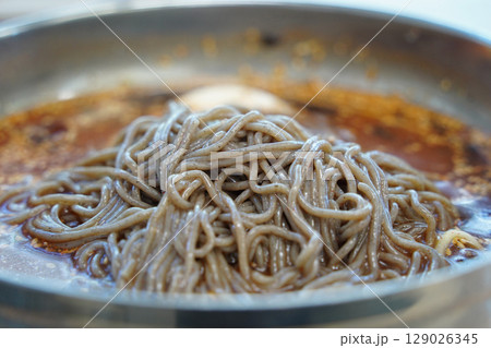 Close-up of Korean Buckwheat Noodles with Braised Pollack in Metal Bowl Close-up of Korean Buckwheat Noodles with Braised Pollack in Metal Bowl 129026345