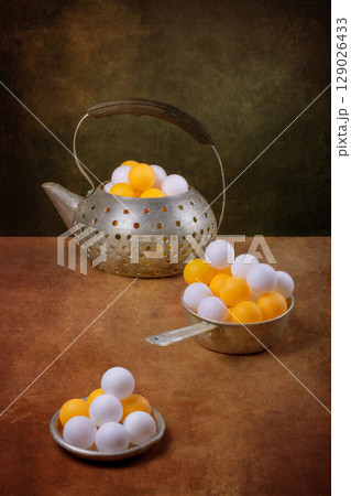 Still life with aluminum teapot and white and orange balls Still life with aluminum teapot and white and orange balls 129026433