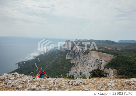 Male looking at the landscape from the top of a mountain on a hike 129027176