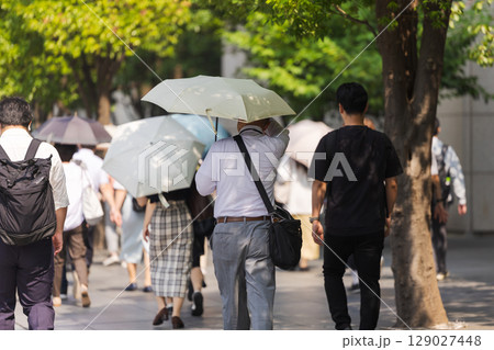 日傘をさす中高年男性の後ろ姿 日傘をさす中高年男性の後ろ姿 129027448