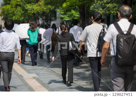 真夏にスーツを着て出勤する女性の後ろ姿 129027451