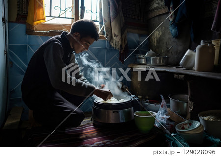 Young man in morocco cooks rice in a humble kitchen, showcasing the rich culinary culture of north Africa 129028096