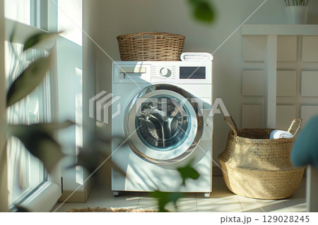 Modern washing machine in a sunlit laundry room with wicker baskets, capturing the essence of household chores and cleanliness 129028245