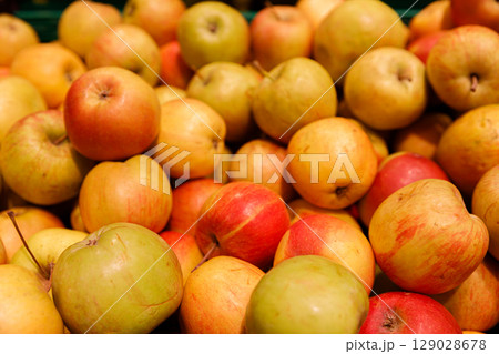 A Colorful Display of Freshly Harvested Apples at a Local Market: A Feast for the Eyes and Taste Buds with Various Shades of Red, Yellow, and Green Among the Abundance of Produce A Colorful Display of Freshly Harvested Apples at a Local Market: A Feast for the Eyes and Taste Buds with Various Shades of Red, Yellow, and Green Among the Abundance of Produce 129028678