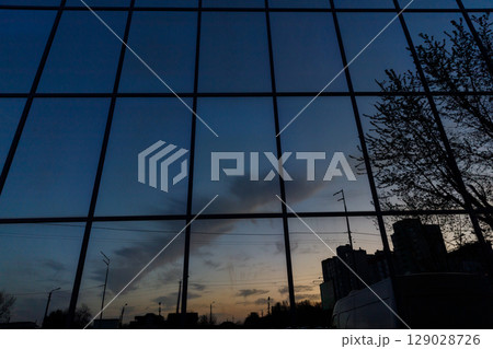 Stunning Reflection of the Dusk Sky Captured on a Modern Glass Building, Enveloping the Scene with a Blend of Natural and Urban Beauty Stunning Reflection of the Dusk Sky Captured on a Modern Glass Building, Enveloping the Scene with a Blend of Natural and Urban Beauty 129028726