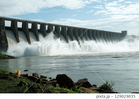 Powerful water jets are gushing out of the dam, generating renewable energy 129029035