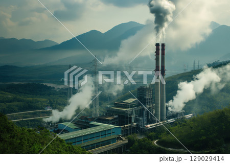 Smoke billowing from a coal fired power station, creating air pollution in a valley 129029414