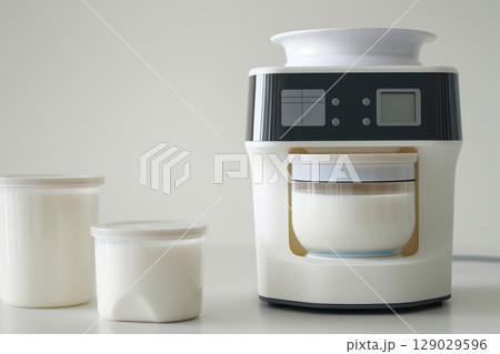 Yogurt maker machine making fresh yogurt with two finished portions in plastic containers on a white background Yogurt maker machine making fresh yogurt with two finished portions in plastic containers on a white background 129029596