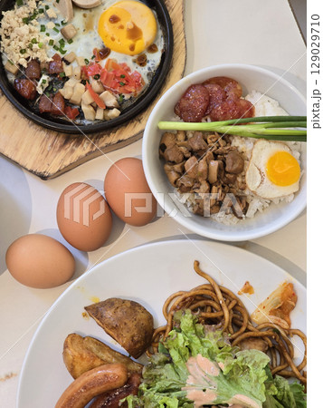 Delicious breakfast spread featuring rice, eggs, meat, and noodles, showcasing variety of flavors and textures that create satisfying meal experience 129029710