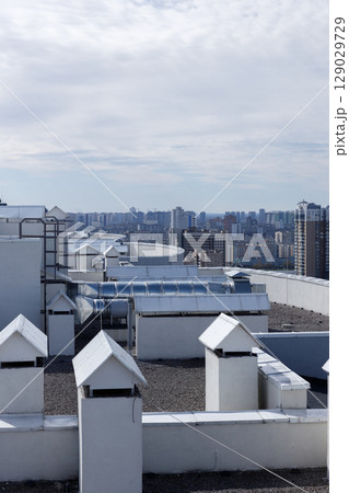 A Panoramic View of Urban Rooftops Surrounded by Modern High-Rise Buildings and a Beautiful Cloudy Sky A Panoramic View of Urban Rooftops Surrounded by Modern High-Rise Buildings and a Beautiful Cloudy Sky 129029729