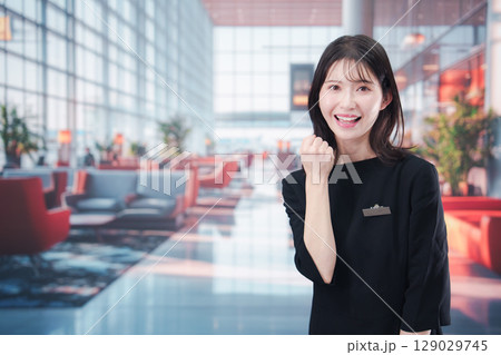 空港のラウンジで接客をする若い女性スタッフ 129029745
