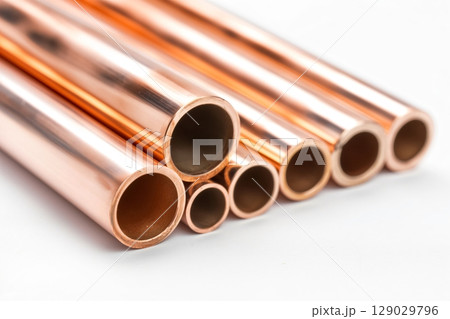 Collection of shiny copper pipes of various diameters arranged neatly on a clean white background, showcasing the beauty of metalwork and plumbing materials Collection of shiny copper pipes of various diameters arranged neatly on a clean white background, showcasing the beauty of metalwork and plumbing materials 129029796