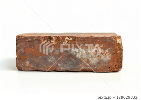 Close up view of an old red brick, showing its weathered texture and isolated on a white background 129029832
