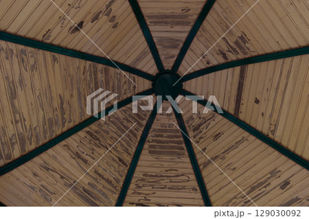 A Unique Perspective of a Vintage Gazebo Roof Showcasing Intricate Wooden Patterns and Decorations with Green Trim Enhancing its Aesthetic Appeal 129030092