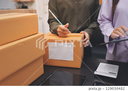 Portrait of Starting small businesses SME owners, two Asian woman check online orders Selling products working with boxs freelance work at home office, sme business online small medium enterprise Portrait of Starting small businesses SME owners, two Asian woman check online orders Selling products working with boxs freelance work at home office, sme business online small medium enterprise 129030482