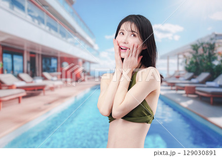 太陽が降り注ぐリゾートで顔に日焼け止めを塗る水着姿の女性 129030891