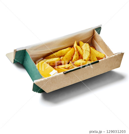 Cardboard box containing potato wedges with cheese sauce for delivery or takeaway Cardboard box containing potato wedges with cheese sauce for delivery or takeaway 129031203