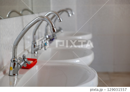 White ceramic washing basins with shiny stainless steel water tap. White ceramic washing basins with shiny stainless steel water tap. 129031557