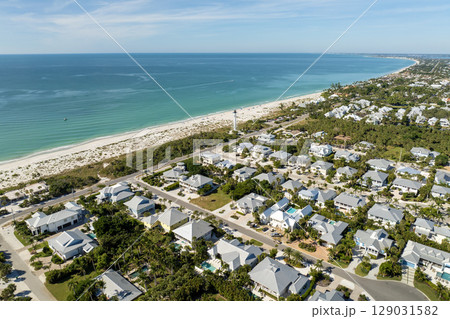 Wealthy neighborhood in small town Boca Grande, Florida with expensive waterfront houses between green palm trees. Development of US premium housing 129031582