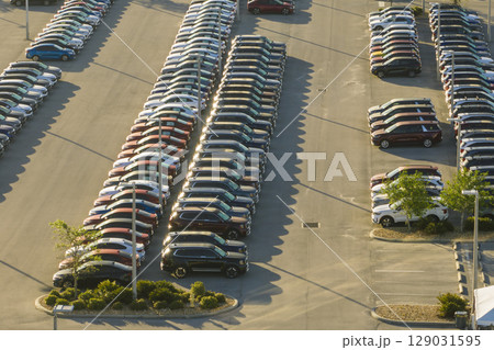 View from above of dealers outdoor parking lot with many brand new cars in stock for sale. Concept of development of american automotive industry View from above of dealers outdoor parking lot with many brand new cars in stock for sale. Concept of development of american automotive industry 129031595