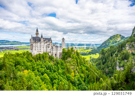 Nestled amidst lush greenery, Neuschwanstein Castle rises majestically above the landscape. Its fairytale structure captivates visitors from near and far throughout the year. Nestled amidst lush greenery, Neuschwanstein Castle rises majestically above the landscape. Its fairytale structure captivates visitors from near and far throughout the year. 129031749