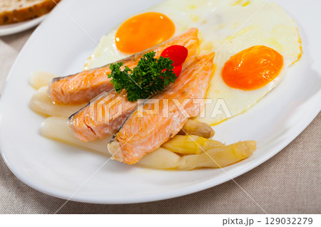 Delicious grilled salmon with eggs, tomatoes, asparagus and parsley 129032279