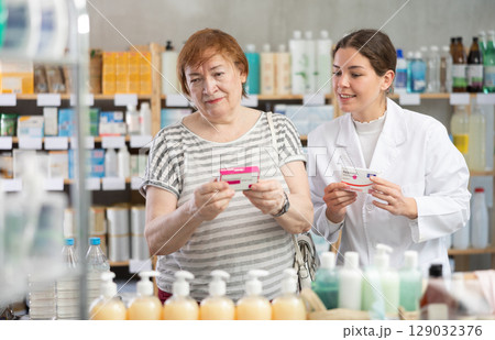 Woman choosing paracetamol with help from pharmacist Woman choosing paracetamol with help from pharmacist 129032376
